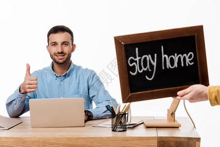 快乐的自由职业者在笔记本电脑和黑板旁竖起大拇指图片