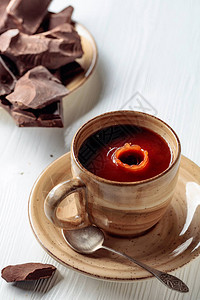 热巧克力和破碎的苦巧克力在白木桌上一杯酒倒在杯子图片