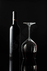 瓶红酒和倒酒杯黑底的葡萄酒酿酒概图片