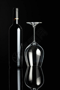 瓶红酒和黑色背景的倒酒杯酿酒概图片