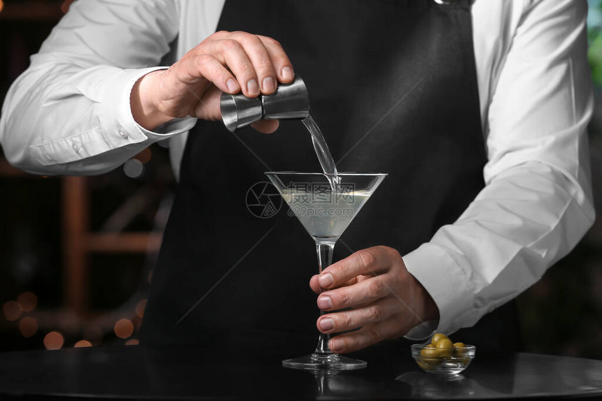 在酒吧里制作新鲜马提尼酒的调酒师图片