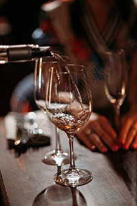 服务员将葡萄酒倒进餐厅的玻璃杯中近距图片