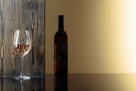 黑桌上的酒瓶和白葡萄酒杯图片