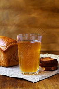一杯自制面包格瓦斯配黑麦面包放在木桌上麻布啤酒垂直的图片