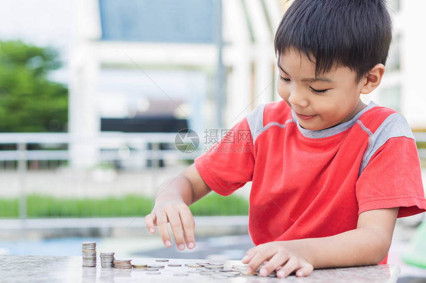 选择焦点5至6岁亚洲儿童男孩练习用木桌上的剪刀彩纸的肖像图在家学习社交距离孩图片
