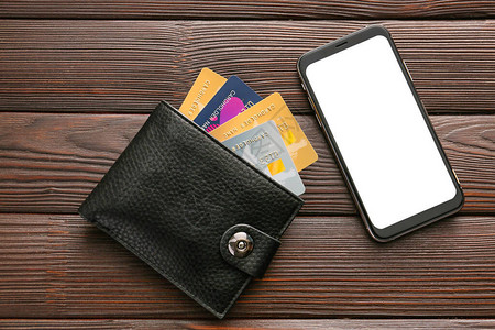 带钱包的信用卡和有木制背景的手机图片