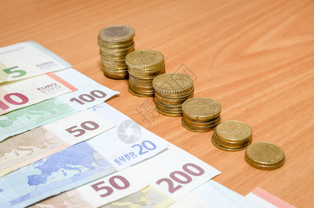 木桌上的欧元纸币和硬币图片