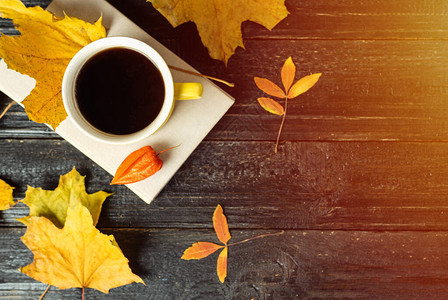 黄色咖啡杯深色木桌上有秋叶复制空间图片
