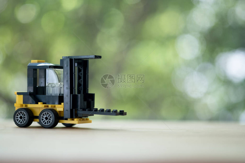 自然背景模糊的木桌上的微型黄色叉车模型仓储物流业务图片