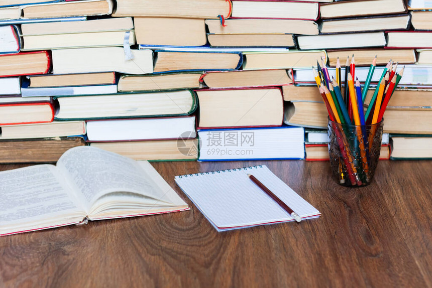开放式教科书笔记本眼镜铅笔架木桌上的一叠旧书教育理念背景许多书堆图片