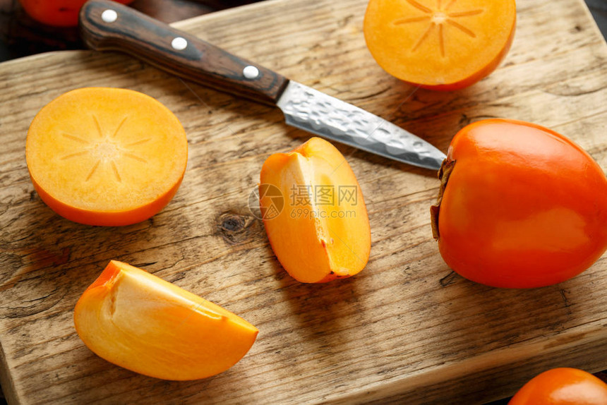 木板上的生熟柿子水果片图片