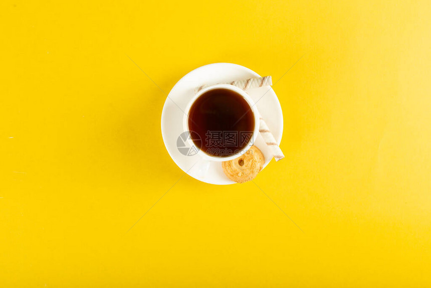 黄色背景上一杯茶有饼干图片