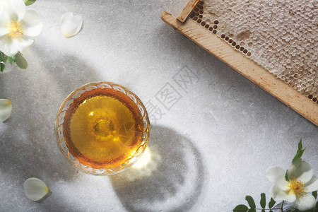 蜂蜜背景玻璃罐里的甜蜂蜜桌子上的蜂蜜图片