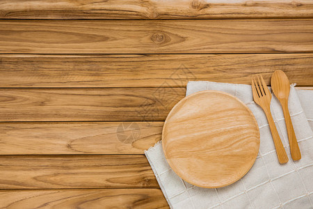木板在白布上有勺子和叉子放图片