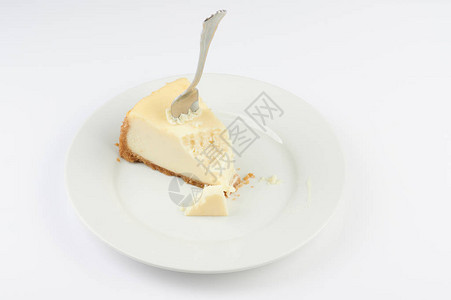 叉子卡在芝士蛋糕里在盘子上咬了一口图片
