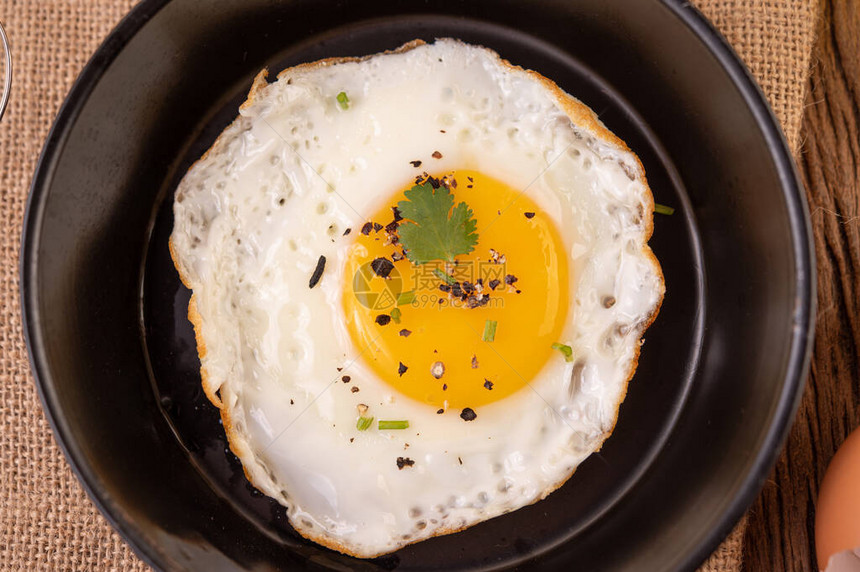 煎锅和生蛋的炸鸡蛋健康有机食图片