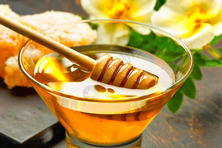 蜂蜜背景蜂蜜与木蜂蜜北斗在木桌上背景图片