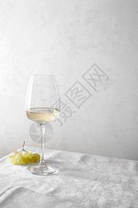 白葡萄酒在杯子里桌子上有一堆葡图片