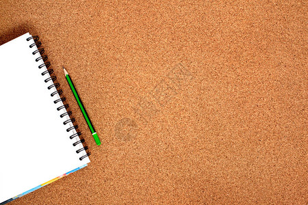 螺旋笔记本和一个简单的绿色铅笔图片