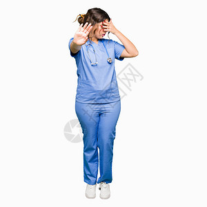 身穿医疗制服的年轻成年女医生用手捂住眼睛图片