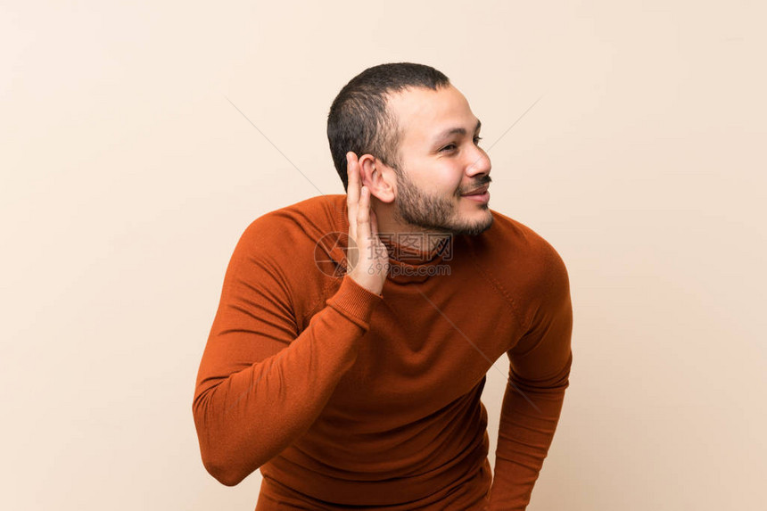 哥伦比亚男子穿着高领毛衣听着一些东西图片