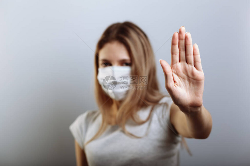 戴面罩的女士用手显示停止牌图片
