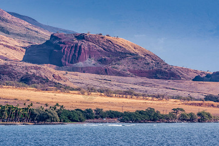 蓝色天空下褐色干燥地貌中的火山塞热石块图片