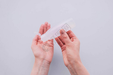 妇女用鼻涕灭菌凝胶给自己的手消毒图片