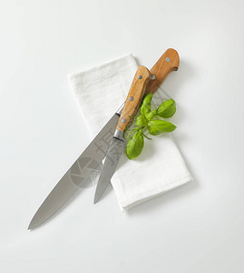 白色餐巾纸上的厨房实用刀和削皮刀图片