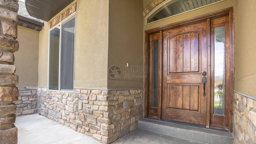 家门廊和棕色木头前门配有侧灯和弓形转筒窗图片