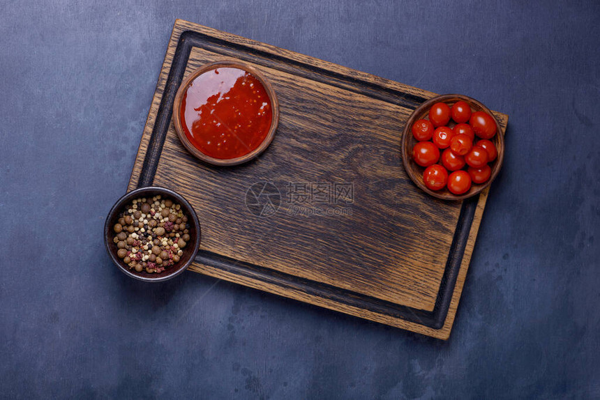 在砧板上用番茄酱和胡椒腌制的西红柿图片