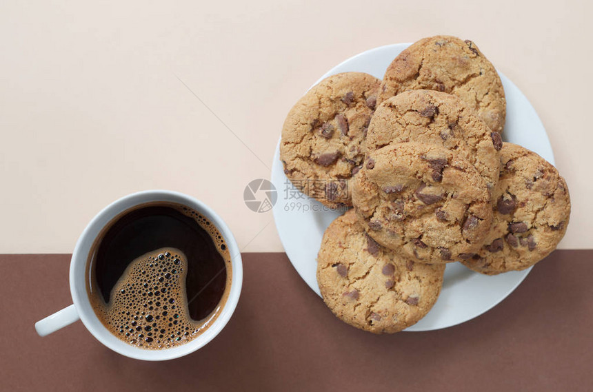 两色背景的咖啡杯和美味巧克力饼干图片