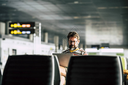 男人坐在机场门口等飞图片