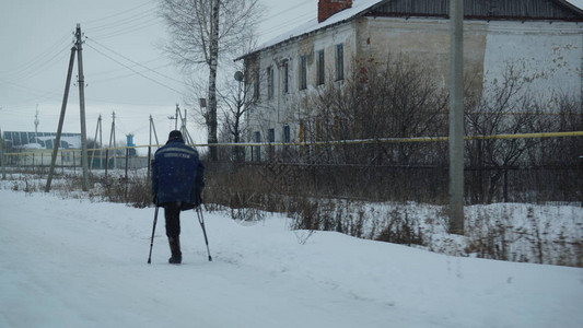 孤单的独腿男子在一个雪地村图片