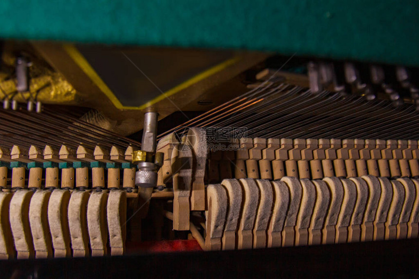 从里面关闭旧的破旧的尘土飞扬的钢琴用废弃的钢琴敲击琴弦的锤子从古老的废弃钢图片