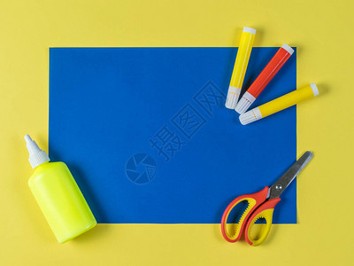 黄色背景的蓝皮纸胶水标记和剪刀背景图片