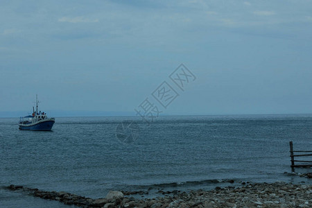 一艘小船游向荒凉的海边图片