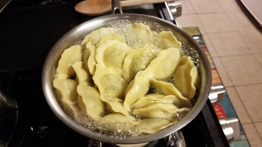 馄饨菠菜面食在炉子上的沸水锅中烹饪图片