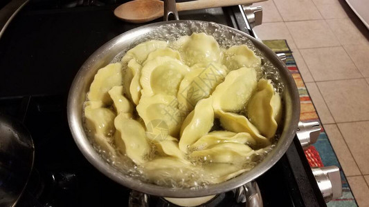 馄饨菠菜面食在炉子上的沸水锅中烹饪图片