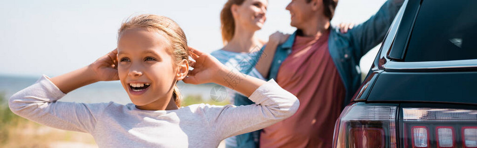 女孩在父母和户外汽车附近看离家的女图片