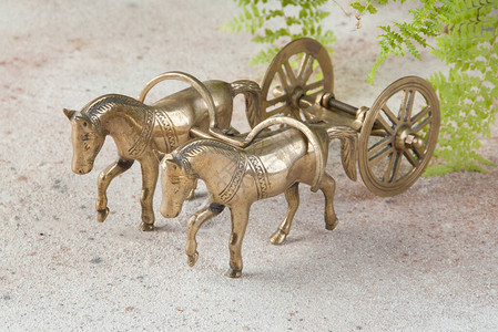 混凝土背景的古董铜马和手工艺雕塑图片