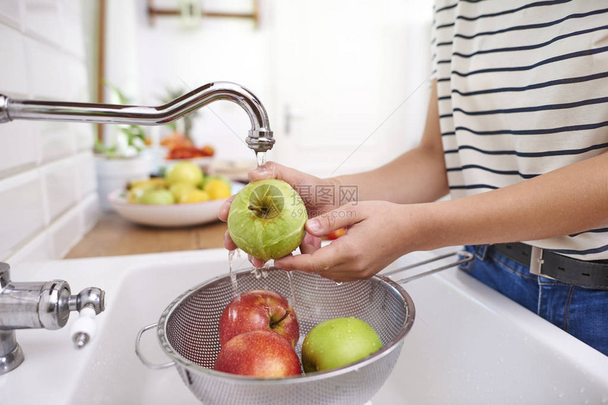 洗时令新鲜苹果的女人图片