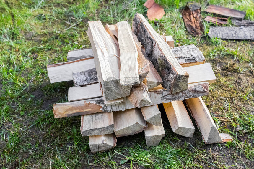 切好的木头躺在草地上为冬天采伐木材和生火森林砍伐问题与图片