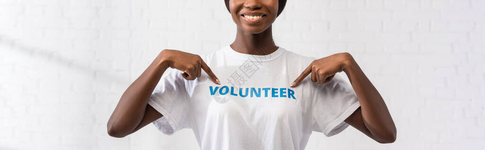AfricanAmerican志工用手指在T恤衫上写字图片