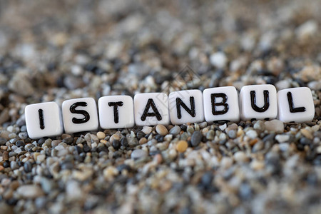 位于海岸沙石上的信写成的印有度假目的地城市名称的伊斯坦布尔文登记文图片