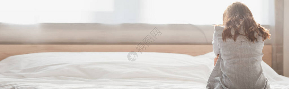 压抑的黑发女人坐在床图片