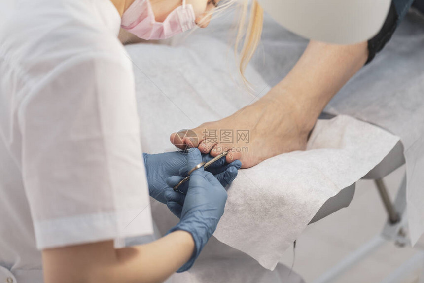 由美容院的修脚专家进行的特写指甲护理修脚透明角质层图片