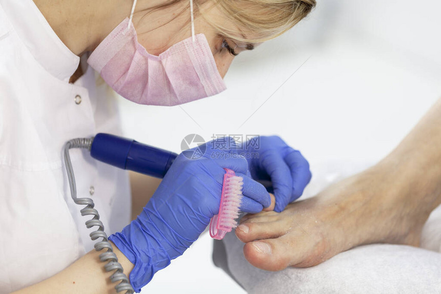 由美容院的修脚专家进行的特写指甲护理修脚透明角质层图片