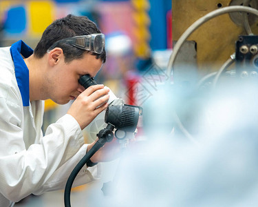 工程师用显微镜检查工厂中铸造的金属模具的正确位置图片