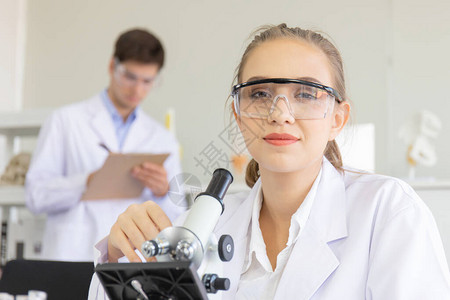 新一代科学研究人员在实验室中通过显微镜观察的概念年轻科学家图片